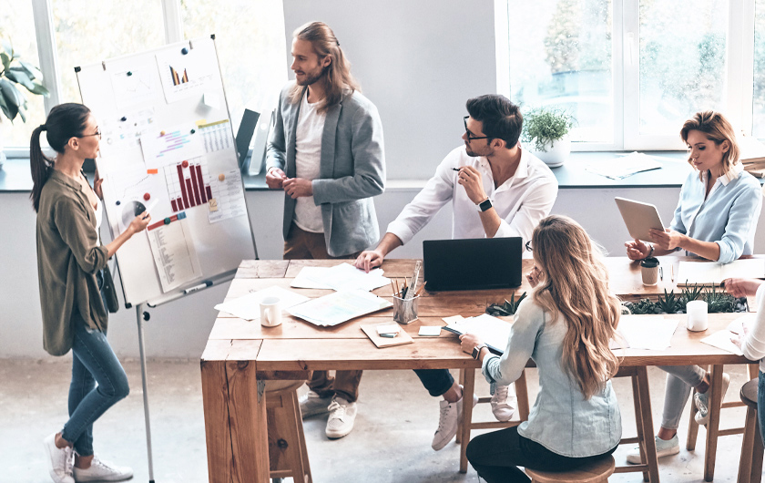 Une équipe dans un bureau échange autour d'une table et d'un ordinateur